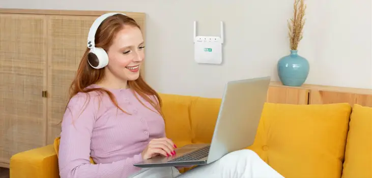 woman happily using her laptop and NetTec Boost being plugged in